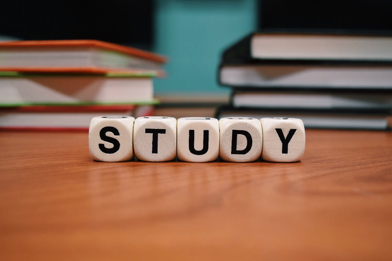 The Art of Drawing Readers In: Your attractive post title goes here Close-up of study blocks and stacked books on a wooden desk, symbolizing education and learning.